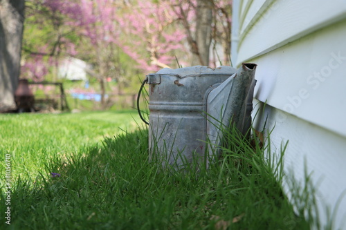 Old rustic watering can in the grass