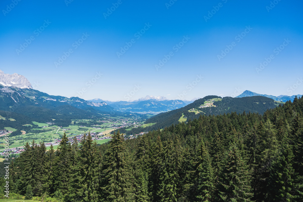 Stimmungsvolle Landschaft mit Tannen, Dörfern und Bergen in den Tiroler Alpen