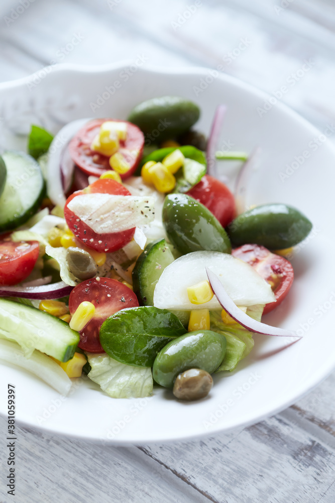 Simple Salad with Green Olives, Cucumber, Cherry Tomatoes and Capers. Bright wooden background. Close up. Simple Salad with Green Olives, Cucumber, Cherry Tomatoes and Capers. Bright wooden background. Close up.