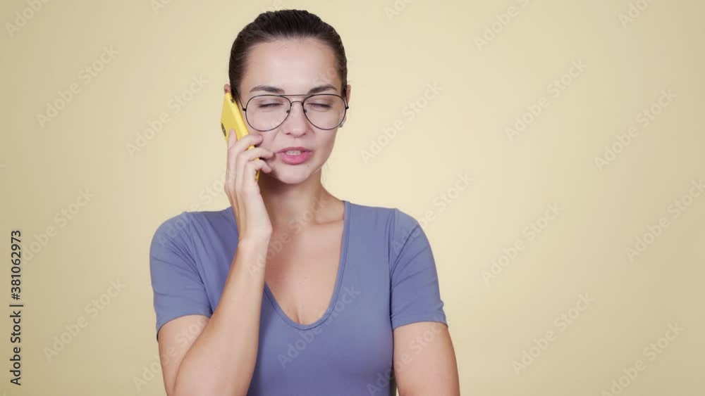 Caucasian beautiful young woman talking via smartphone isolated on beige background Caucasian beautiful young woman talking via smartphone isolated on beige background