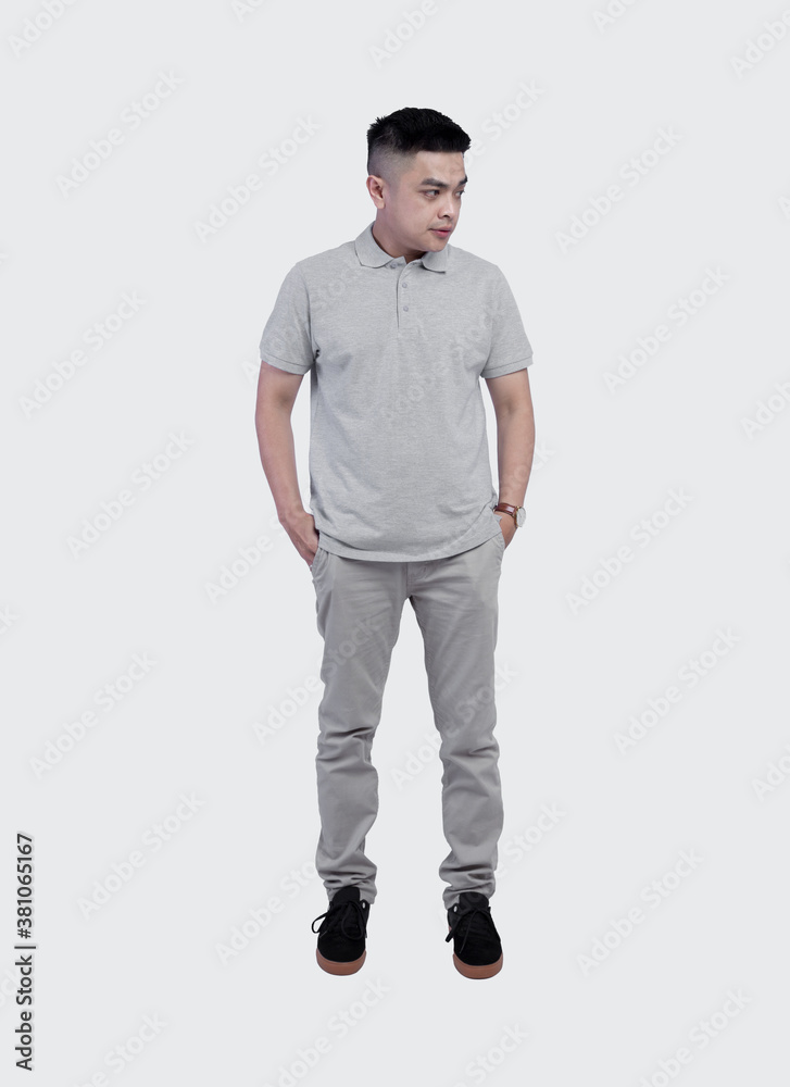 Full shot of Handsome man wearing grey polo shirt posing at plain background Full shot of Handsome man wearing grey polo shirt posing at plain background