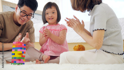 Happy family with mother, father and disabled daughter spending time together at home..