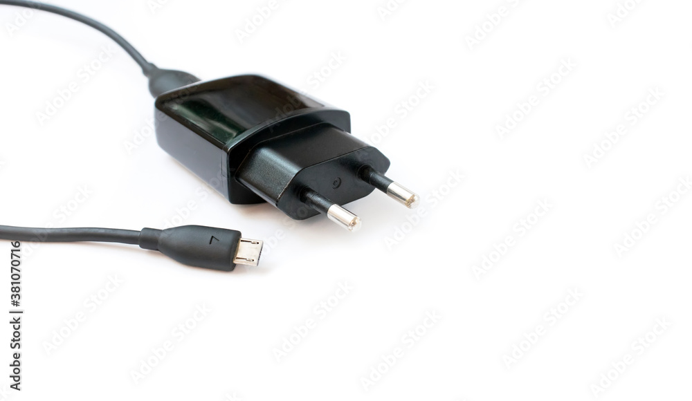 The charger for the mobile phone smartphone is black on a white background The charger for the mobile phone smartphone is black on a white background