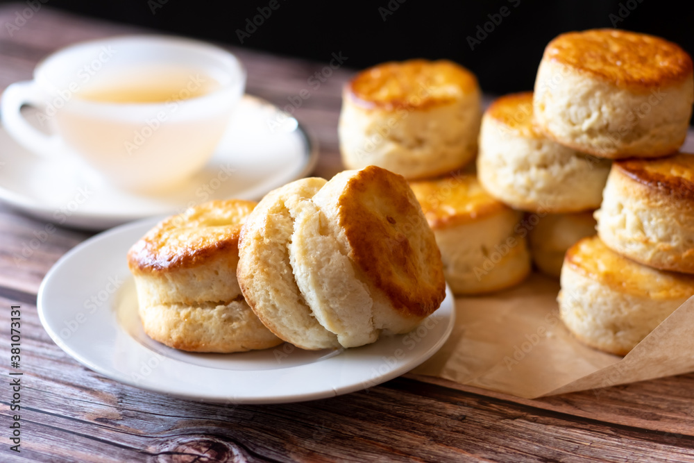 Close up group of fresh yummy tasty delicious Traditional British Scones and a cup of tea on wooden table  background. 