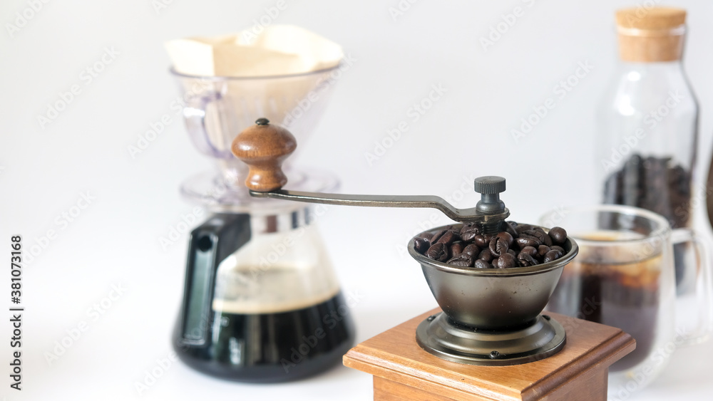 Coffee set, fresh roasted coffee beans in the mill manual coffee grinder and glass bottle black coffee paper drip isolated white background