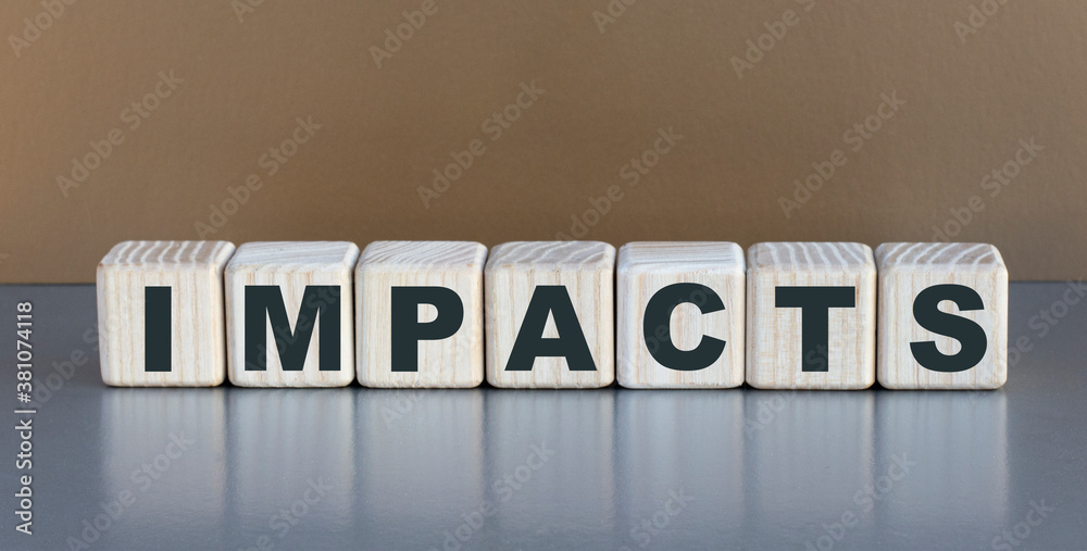 Obraz premium IMPACTS - word on wooden cubes on a beautiful gray background