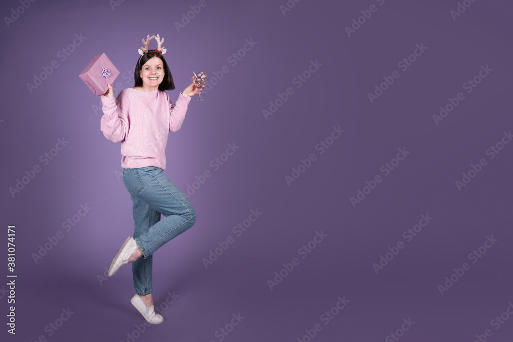Happy Christmas woman with gift and Xmas decorations on purple banner background with copy space Happy Christmas woman with gift and Xmas decorations on purple banner background with copy space