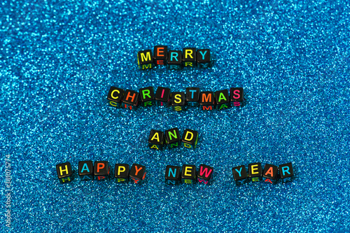 New Year, Christmas text on shiny blue background. Merry Christmas and Happy New Year greeting card, frame, banner. Winter holiday xmas concept
