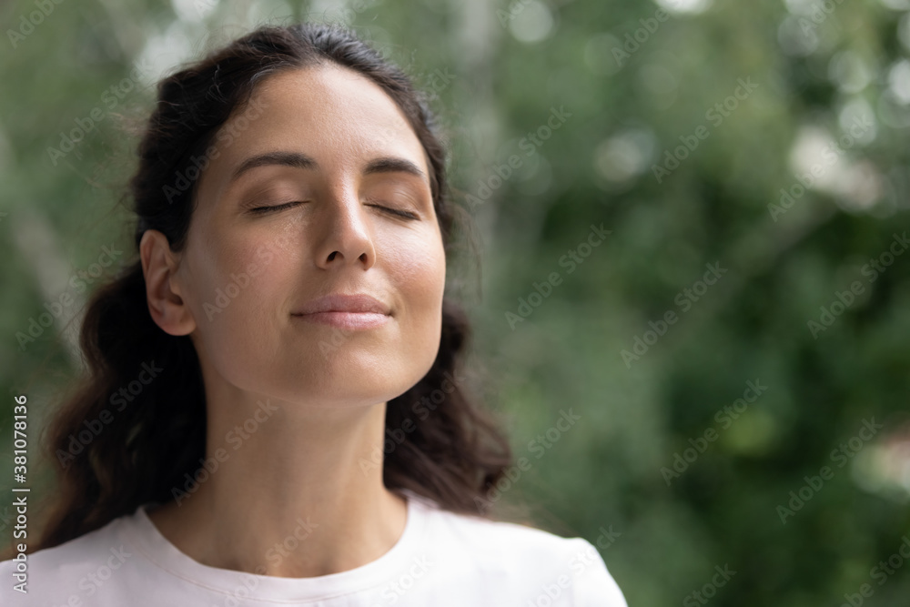 Close up of happy young Caucasian woman isolated on blurred background dream visualize with eyes closed. Smiling dreamy female breathe fresh air relieve negative emotions. Stress free concept. Close up of happy young Caucasian woman isolated on blurred background dream visualize with eyes closed. Smiling dreamy female breathe fresh air relieve negative emotions. Stress free concept.