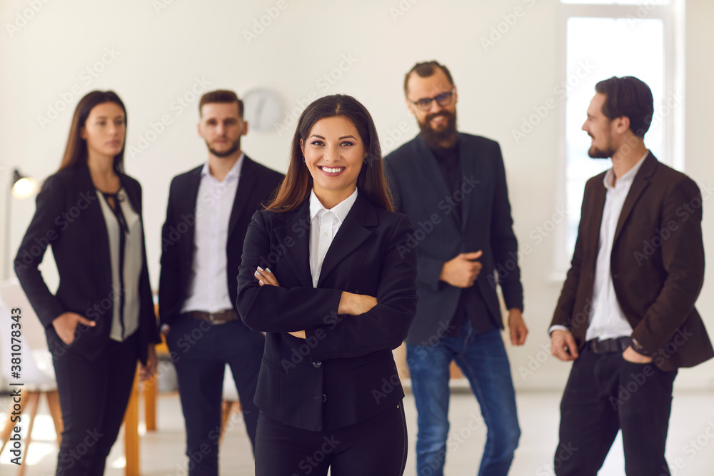Happy young female team leader or executive manager smiling and looking at camera Happy young female team leader or executive manager smiling and looking at camera