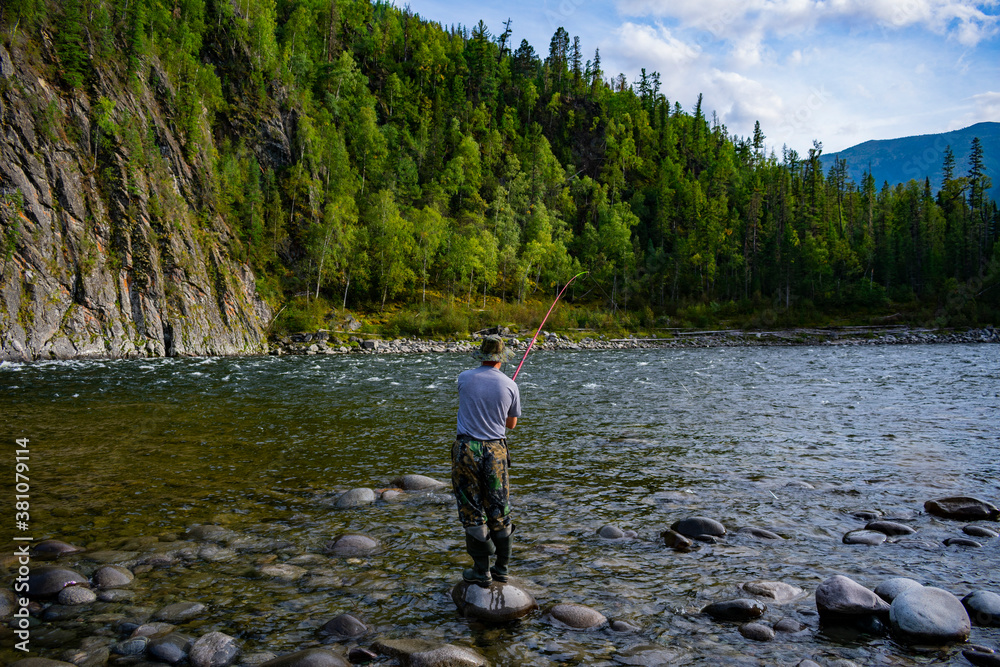 Fisherman on the banks of a mountain river Fisherman on the banks of a mountain river