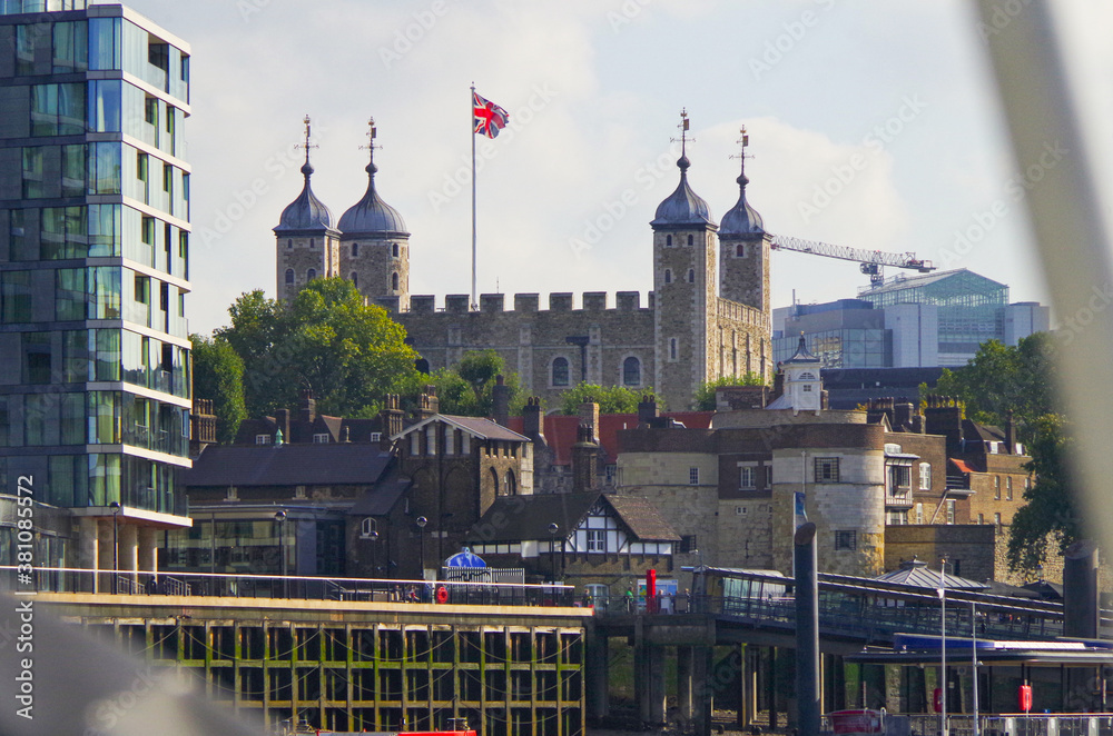Tower of London with Union Jack flag and river bank buildings and promenade - obrazy, fototapety, plakaty 