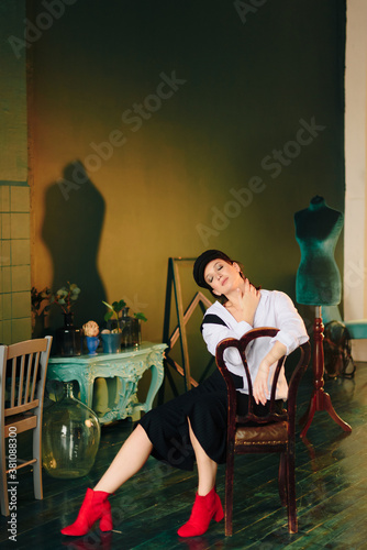 Portrait of a beautiful young woman in a white shirt and black trousers at home