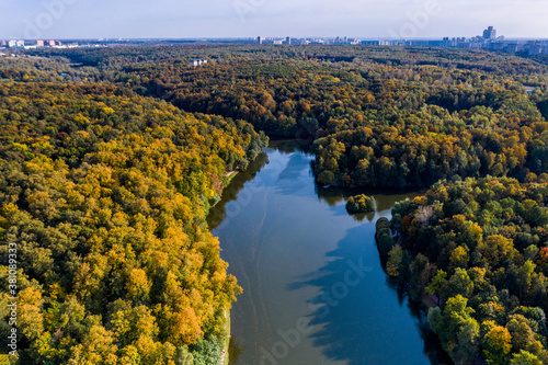 a panoramic view of the historic lake and park complex with roads and bridges filmed from a drone