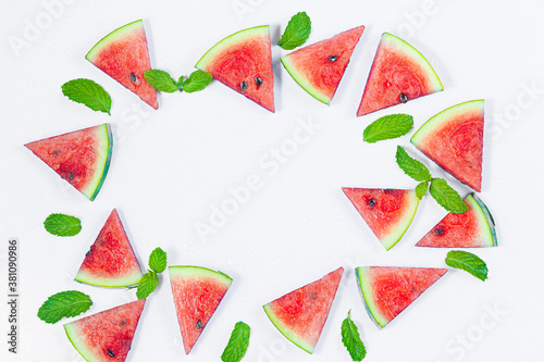 Fototapeta Naklejka Na Ścianę i Meble -  Creative summer food concept. Watermelon pattern. Juicy slices of ripe red watermelon and mint leaves on white background. Flat lay, top view, copy space. Summer berry, healthy nutrition, vitamins