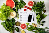 Smartphone and diet plan with food. Top view