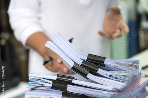 Employee woman hands checking Business unfinished Documents with stacks paper files and searching document achieves preparing meeting planing at busy work desk office