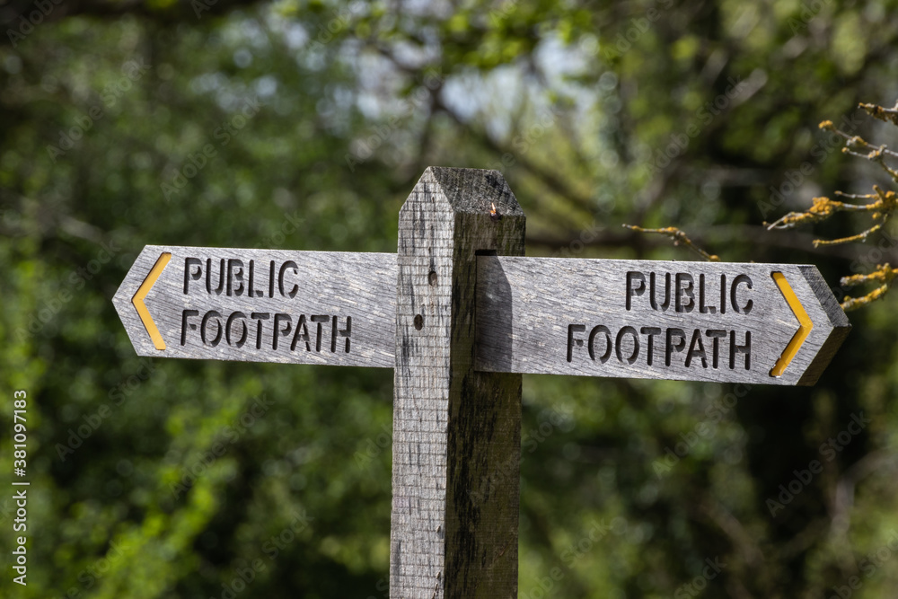 A wooden public footpath sign in the countryside