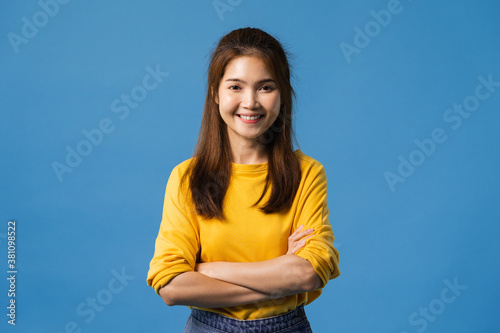 Portrait of young Asia lady with positive expression, arms crossed, smile broadly, dressed in casual clothing and looking at camera over blue background. Happy adorable glad woman rejoices success.