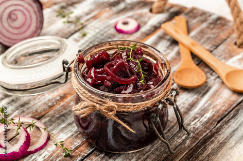 Homemade onion marmalade jam, confiture, chutney on a rustic wooden table. Delicious sauce. French cuisine photo