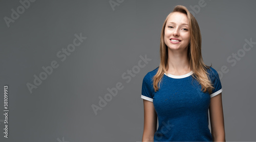 Positive Young blonde woman laughing. Studio shot, gray background. Human emotions facial expression concept. Copy space