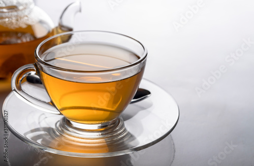The hot teacup and teapot transparent on the white table photo