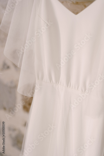 Close-up of the fabric of the bride's white wedding dress.