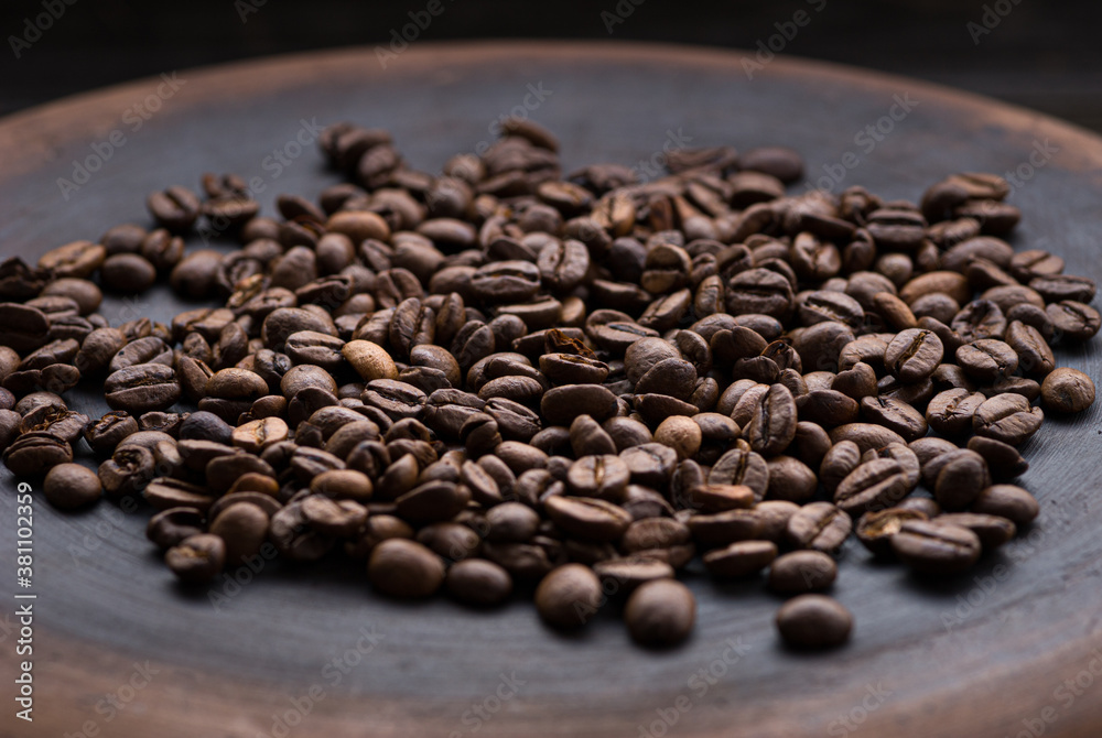Fototapeta premium roasted aromatic coffee beans closeup sprinkled on a table