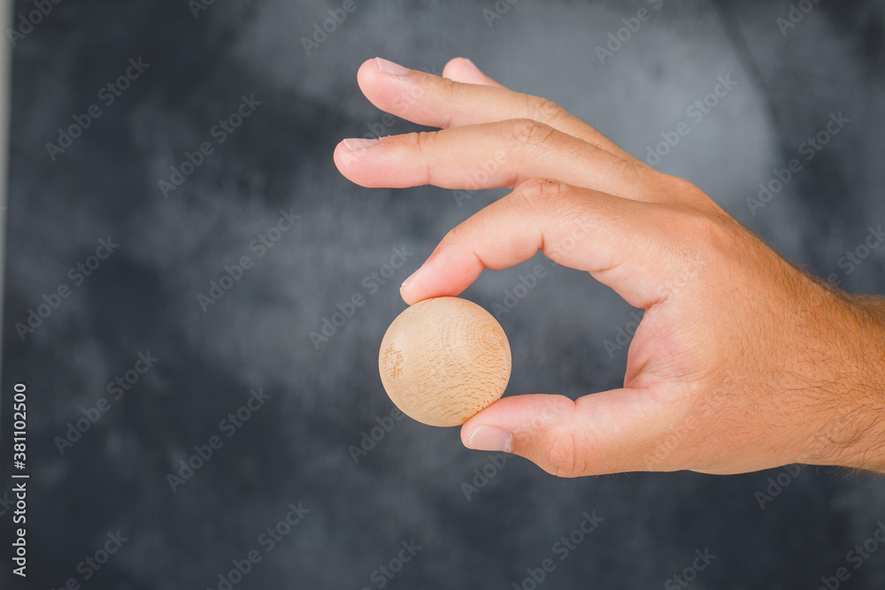Business strategy concept on foggy background side view. hand holding wooden sphere. Business strategy concept on foggy background side view. hand holding wooden sphere.