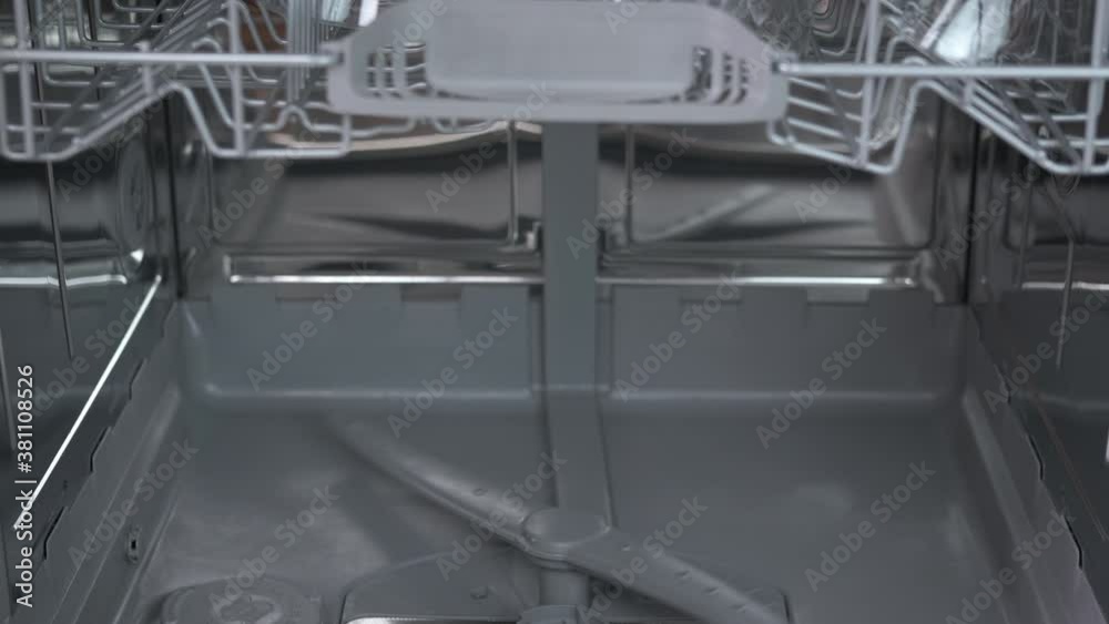Inside dishwash machine. A view of a working dishwasher machine inside in the kitchen. Inside dishwash machine. A view of a working dishwasher machine inside in the kitchen.