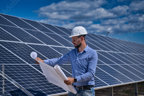 The engineer is checking the project of the solar station.