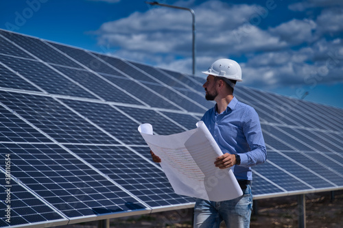 The engineer is checking the project of the solar station.