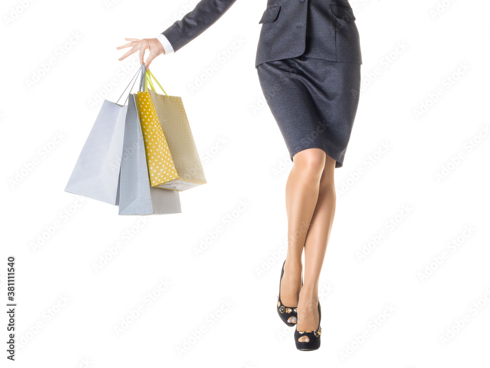 Close-up female legs and a hand with a shopping bags.