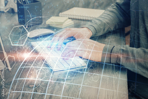 Multi exposure of world map hologram with man working on computer on background. Concept of worldwideweb.