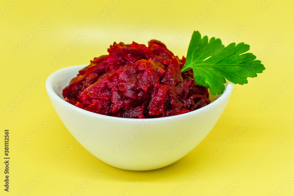 Grated beets. Fresh beet salad in white bowl isolated on yellow background. Healthy food concept, diet, fresh vegetables, vitamins and liver recovery. Grated beets. Fresh beet salad in white bowl isolated on yellow background. Healthy food concept, diet, fresh vegetables, vitamins and liver recovery.