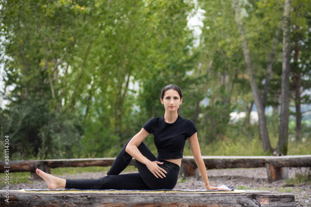 a woman does yoga in the forest in nature in the Park a woman does yoga in the forest in nature in the Park