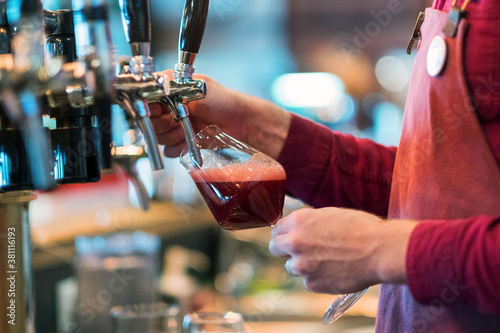 Bright metal beer tap, natural light, red beer