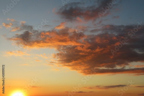 Beautiful yellow golden sunset in the sky with dark orange clouds  natural sunset background