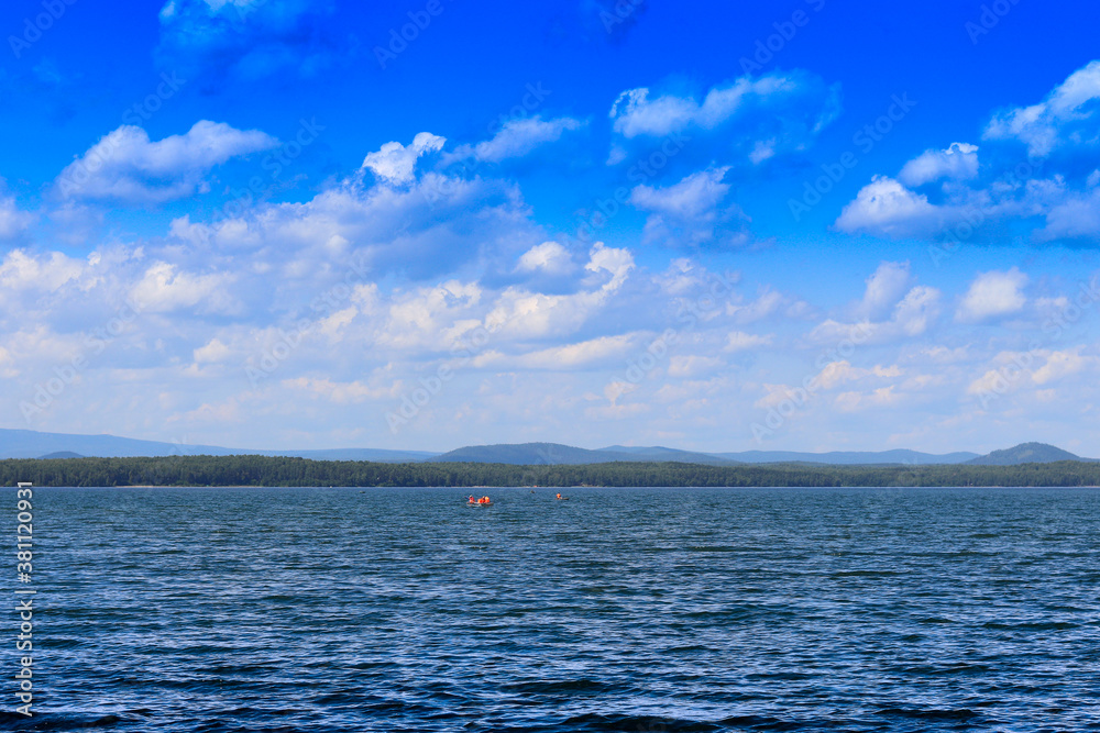 Obraz premium View of the opposite shore of the lake in the afternoon.