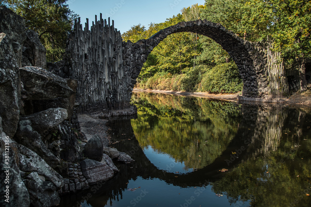 Ancient stone bridge in water reflection