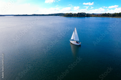 Aerial view of the yacht sailing on a Lubikowskie lake at perfect weather conditions in summer, Poland 