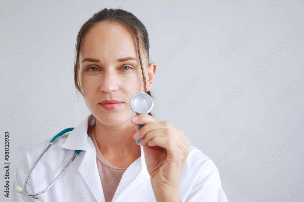 Smiling Beautiful caucasian doctor woman in Gown uniform and hand holding stethoscope is smart portrait on white wall background. Smiling Beautiful caucasian doctor woman in Gown uniform and hand holding stethoscope is smart portrait on white wall background.