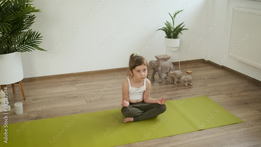 Little Caucasian 5 year old girl meditates at home. Yoga. Lotus pose. Health Little Caucasian 5 year old girl meditates at home. Yoga. Lotus pose. Health
