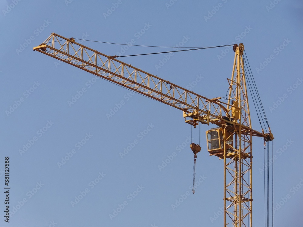 yellow construction crane on blue sky background resting after work