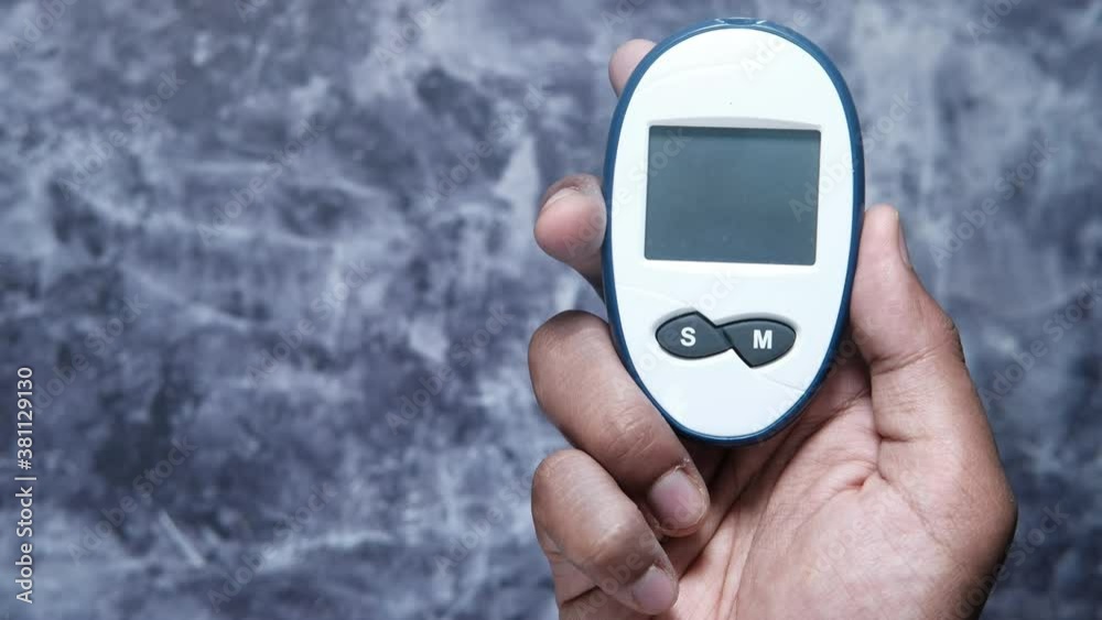 young man's hand measure glucose level at home young man's hand measure glucose level at home