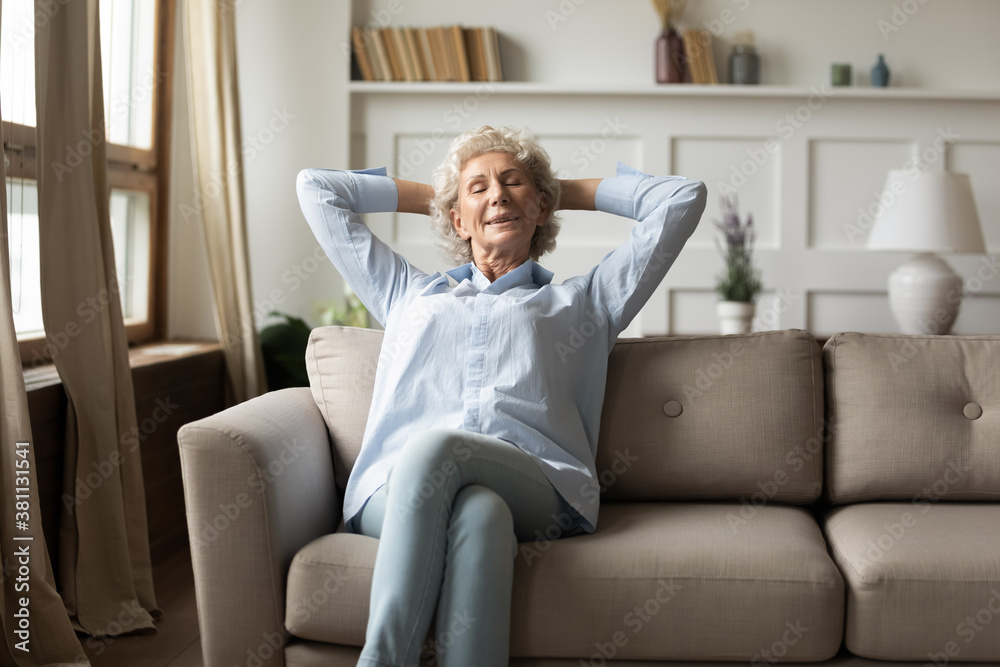 What a good day. Peaceful happy grey-haired old woman relaxing on comfy couch in living room at home, sitting calm with closed eyes smiling and daydreaming, napping, taking break in domestic work What a good day. Peaceful happy grey-haired old woman relaxing on comfy couch in living room at home, sitting calm with closed eyes smiling and daydreaming, napping, taking break in domestic work