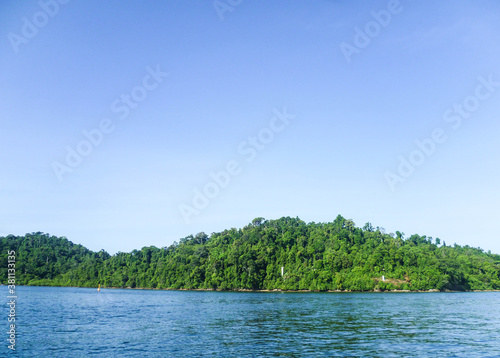 Heavily overgrown coast of the Andaman Sea in Thailand. Excursion by boat.