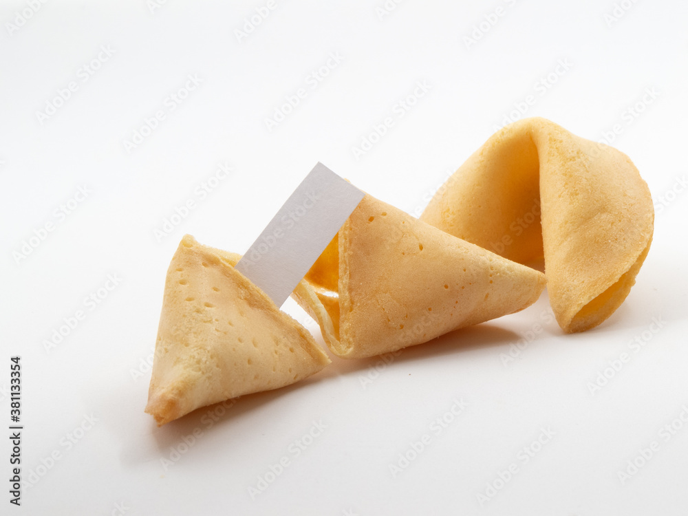 Two fortune cookies with one opened and a small blank piece of pager visible in front of white background Two fortune cookies with one opened and a small blank piece of pager visible in front of white background
