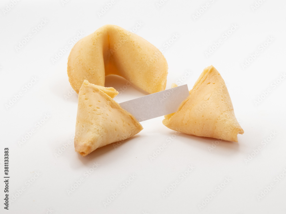 Two fortune cookies with one opened and a small blank piece of pager visible in front of white background Two fortune cookies with one opened and a small blank piece of pager visible in front of white background