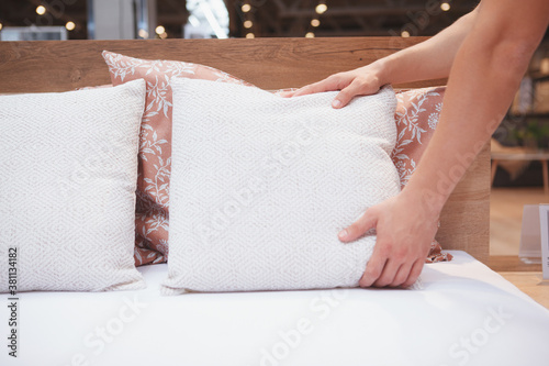 Croppe shot of unrecognizable man making his be, putting on pillows photo